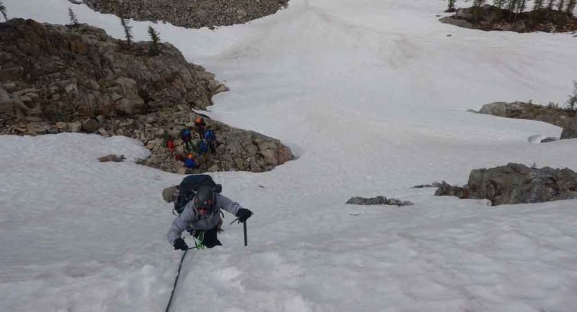 a person ascends up a snowy bank on a mountaineering course with outward bound